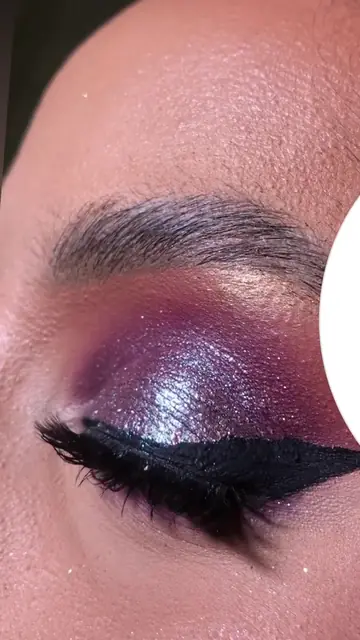 Detalhe de olho esfumado roxo com glitter