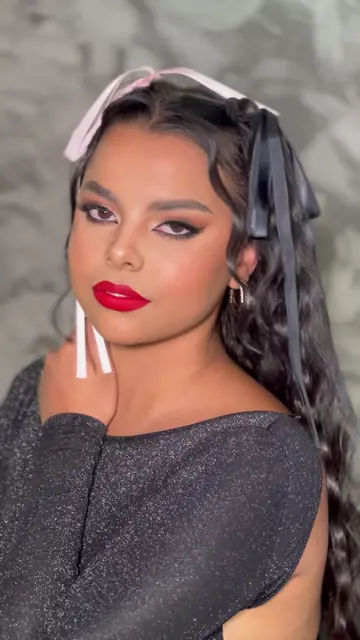 Maquiagem com batom vermelho e laço no cabelo